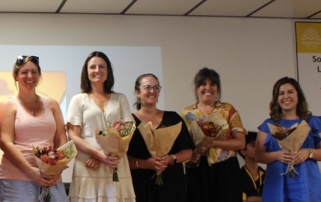 five mothers from the P&C, each holding a bouquet of flowers