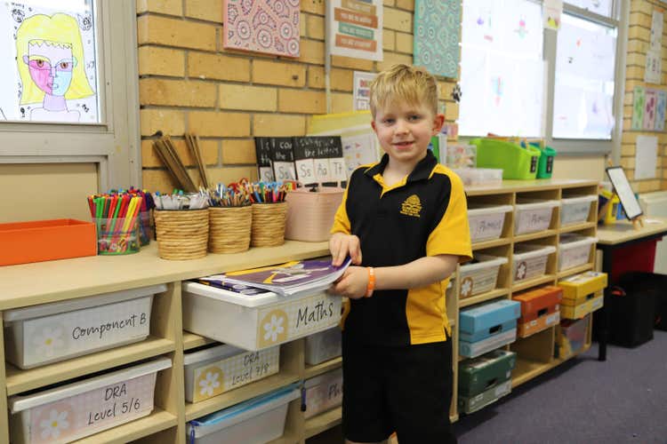 a male student opening a tote tray in a classroom